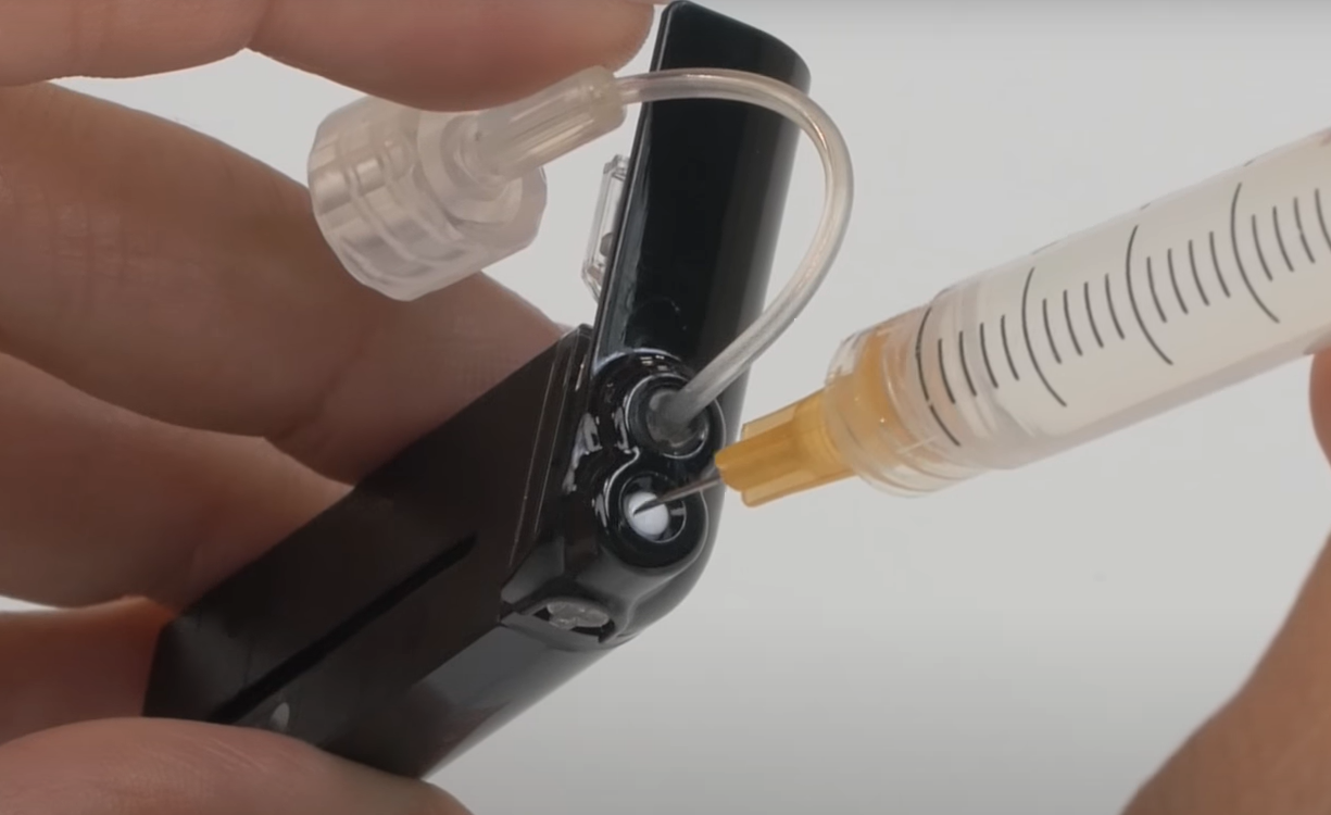 image_of_inserting_needle_into_the_white_cartridge_septum.png